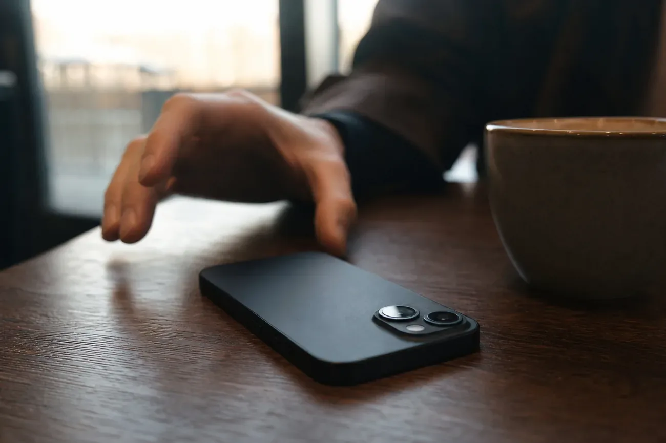 Celular apagado sobre una mesa de café con luz suave de mañana
