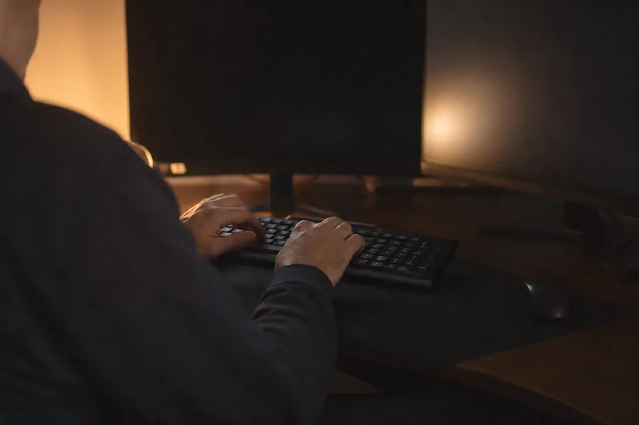 Persona escribiendo en otra computadora para localizar su laptop robada desde su cuenta