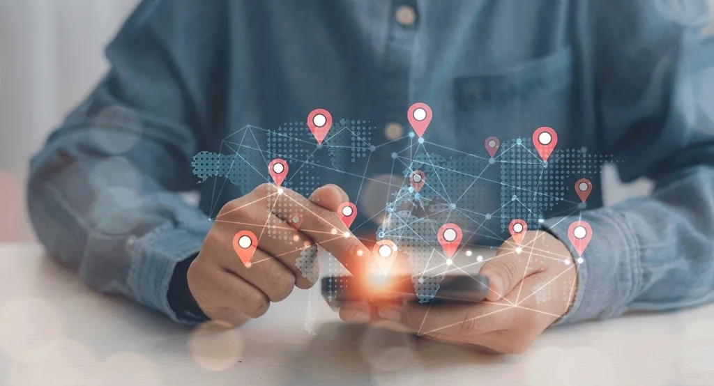 Phone with location pins overlaid on a world map