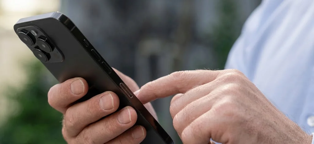 Hands holding a black smartphone